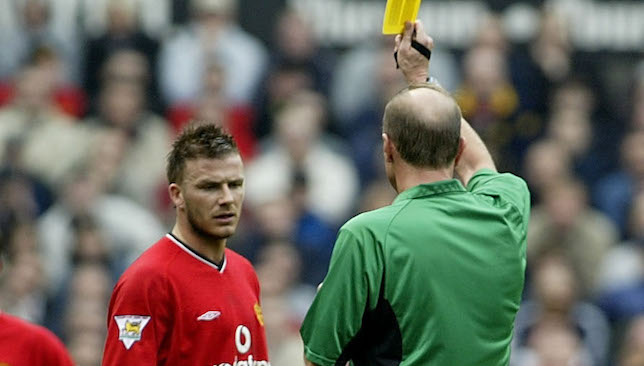 David Beckham receives a yellow card from Steve Bennett.