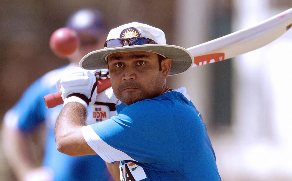 Faridabad, INDIA: Indian batsman Virender Sehwag bats in the nets during a practice session at the Nahar Singh Cricket Stadium in Faridabad, some 30 kms east of New Delhi 30 March 2006 as captain Rahul Dravid (C) and coach Greg Chappell (L) looks on. India will play the second One-Day International cricket match against England at Faridabad 31 March, as they hold a 1-0 lead in the seven-match series. AFP PHOTO/ MANAN VATSYAYANA (Photo credit should read Manan Vatsyayana/AFP/Getty Images)