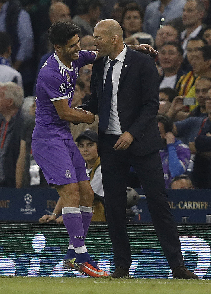 Real Madrid's Spanish midfielder Marco Asensio (L) celebrates with Real Madrid's French coach Zinedine Zidane after scoring their fourth goal during the UEFA Champions League final football match between Juventus and Real Madrid at The Principality Stadium in Cardiff, south Wales, on June 3, 2017. / AFP PHOTO / Adrian DENNIS (Photo credit should read ADRIAN DENNIS/AFP/Getty Images)