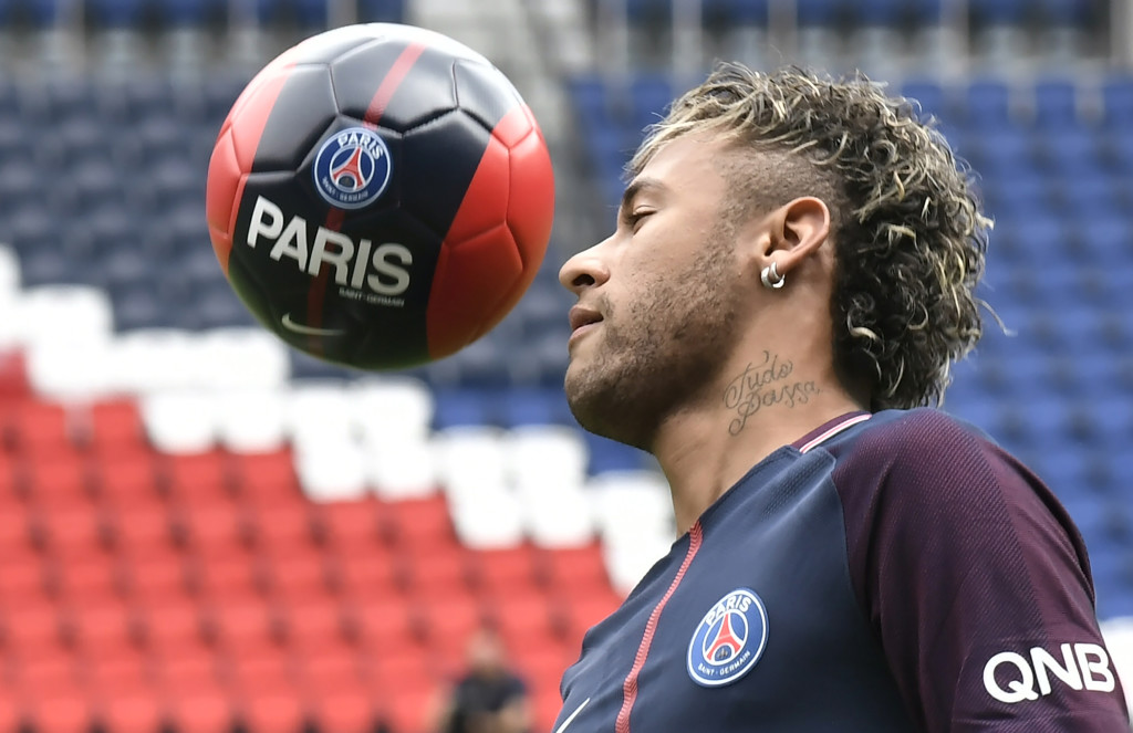 Brazilian superstar Neymar plays with a ball during his official presentation at the Parc des Princes stadium on August 4, 2017 in Paris after agreeing a five-year contract following his world record 222 million euro ($260 million) transfer from Barcelona to Paris Saint Germain's (PSG). Paris Saint-Germain have signed Brazilian forward Neymar from Barcelona for a world-record transfer fee of 222 million euros (around $264 million), more than doubling the previous record. Neymar said he came to Paris Saint-Germain for a "bigger challenge" in his first public comments since arriving in the French capital. / AFP PHOTO / PHILIPPE LOPEZ (Photo credit should read PHILIPPE LOPEZ/AFP/Getty Images)