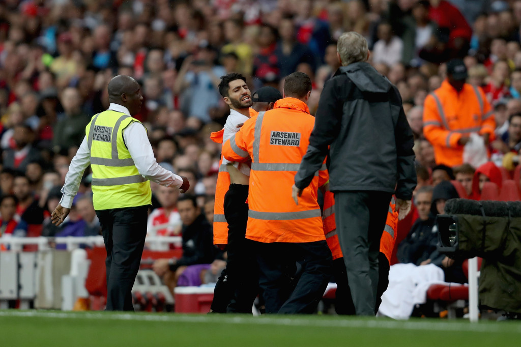 A pitch invader shouts at Wenger during the pre-season clash with Benfica 