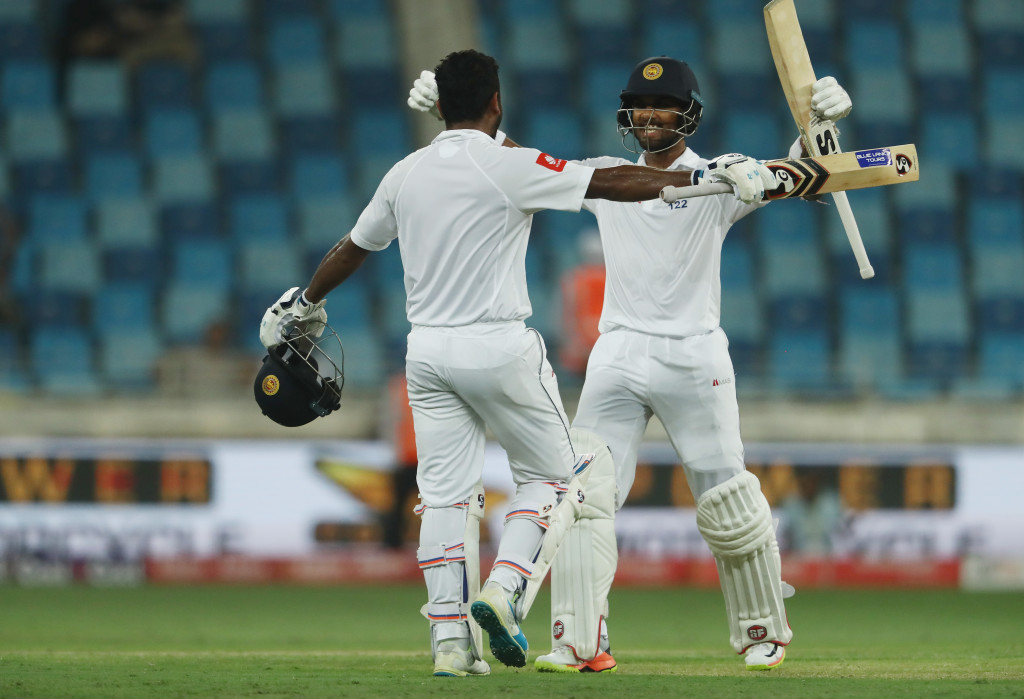 DUBAI, UNITED ARAB EMIRATES - OCTOBER 06: Dimuth Karunaratne of Sri Lanka is congratulated by Dinesh Chandimal of Sri Lanka after reaching his century during Day One of the Second Test between Pakistan and Sri Lanka at Dubai International Cricket Ground on October 6, 2017 in Dubai, United Arab Emirates. (Photo by Francois Nel/Getty Images)