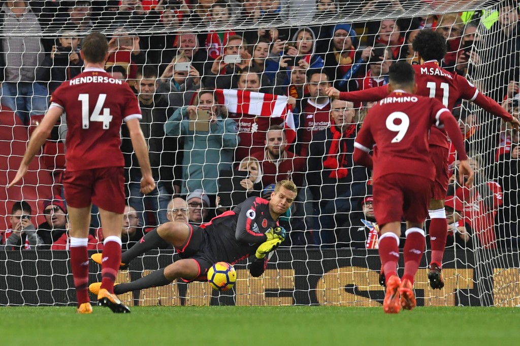Huddersfield Town's Danish goalkeeper Jonas Lossl (C) saves a penalty from Liverpool's Egyptian midfielder Mohamed Salah (R) during the English Premier League football match between Liverpool and Huddersfield Town at Anfield in Liverpool, north west England on October 28, 2017. / AFP PHOTO / Paul ELLIS / RESTRICTED TO EDITORIAL USE. No use with unauthorized audio, video, data, fixture lists, club/league logos or 'live' services. Online in-match use limited to 75 images, no video emulation. No use in betting, games or single club/league/player publications. / (Photo credit should read PAUL ELLIS/AFP/Getty Images)