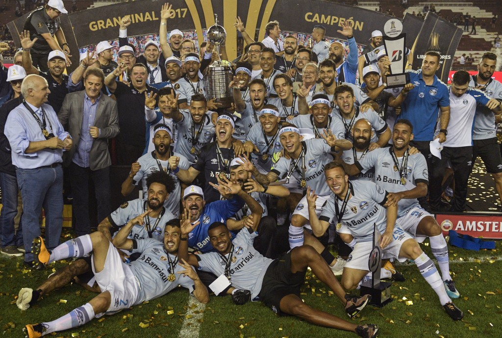 Brazil's Gremio celebrate with the trophy after winning the Copa Libertadores 2017 final football match against Argentina's Lanus at Lanus stadium in Lanus, Buenos Aires, Argentina, on November 29, 2017.  Gremio won 2-1 to become the champion of the Copa Libertadores 2017. / AFP PHOTO / JUAN MABROMATA        (Photo credit should read JUAN MABROMATA/AFP/Getty Images)