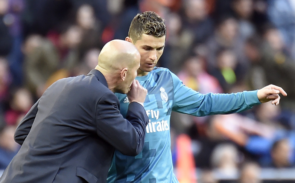 Real Madrid's French coach Zinedine Zidane talks to Real Madrid's Portuguese forward Cristiano Ronaldo (R) during the Spanish league football match between Valencia CF and Real Madrid CF at the Mestalla stadium in Valencia on January 27, 2018. / AFP PHOTO / JOSE JORDAN (Photo credit should read JOSE JORDAN/AFP/Getty Images)