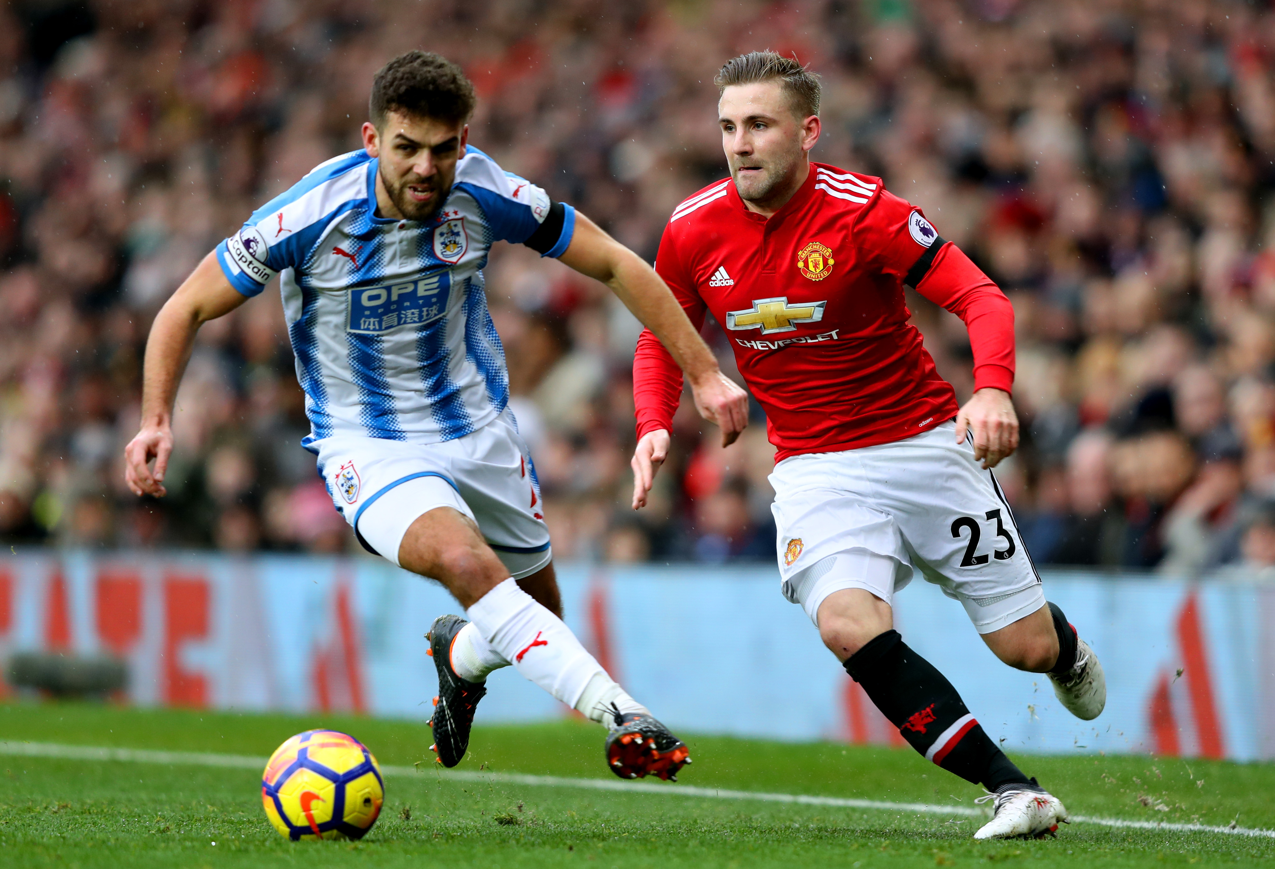 Luke Shaw (r) competes with Huddersfield's Tommy Smith.