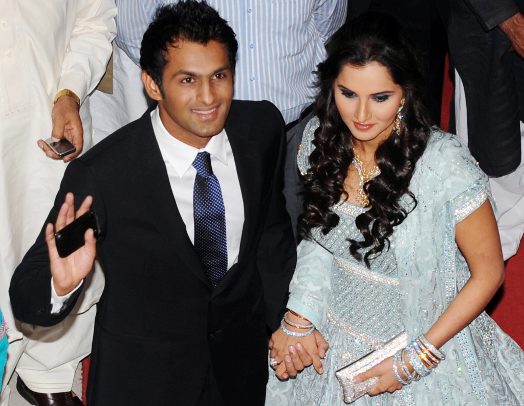 Indian tennis star Sania Mirza (R) holds her husband and Pakistani cricketer Shoaib Malik's hand as they arrive at their wedding reception in Lahore on April 27, 2010. Newlywed and hailed as cross-border peace ambassadors, Mirza and Malik arrived in Pakistan on April 22 to a frenzied reception. The pair is in Pakistan for a week of celebrations -- after a tough engagement and media frenzy that saw Muslim elders called in to arrange a divorce for Malik from a wife he long-denied ever having. AFP PHOTO/ ARIF ALI (Photo credit should read Arif Ali/AFP/Getty Images)