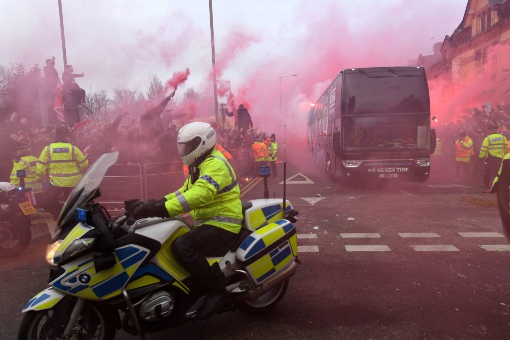 The Manchester City bus makes its way through smoke and beercans.