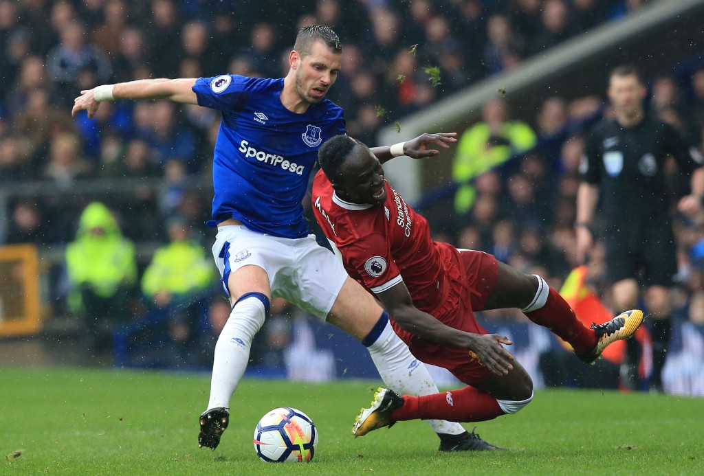 Everton's French midfielder Morgan Schneiderlin (L) tackles Liverpool's Senegalese midfielder Sadio Mane (R) during the English Premier League football match between Everton and Liverpool at Goodison Park in Liverpool, north west England on April 7, 2018. / AFP PHOTO / Lindsey PARNABY / RESTRICTED TO EDITORIAL USE. No use with unauthorized audio, video, data, fixture lists, club/league logos or 'live' services. Online in-match use limited to 75 images, no video emulation. No use in betting, games or single club/league/player publications. / (Photo credit should read LINDSEY PARNABY/AFP/Getty Images)