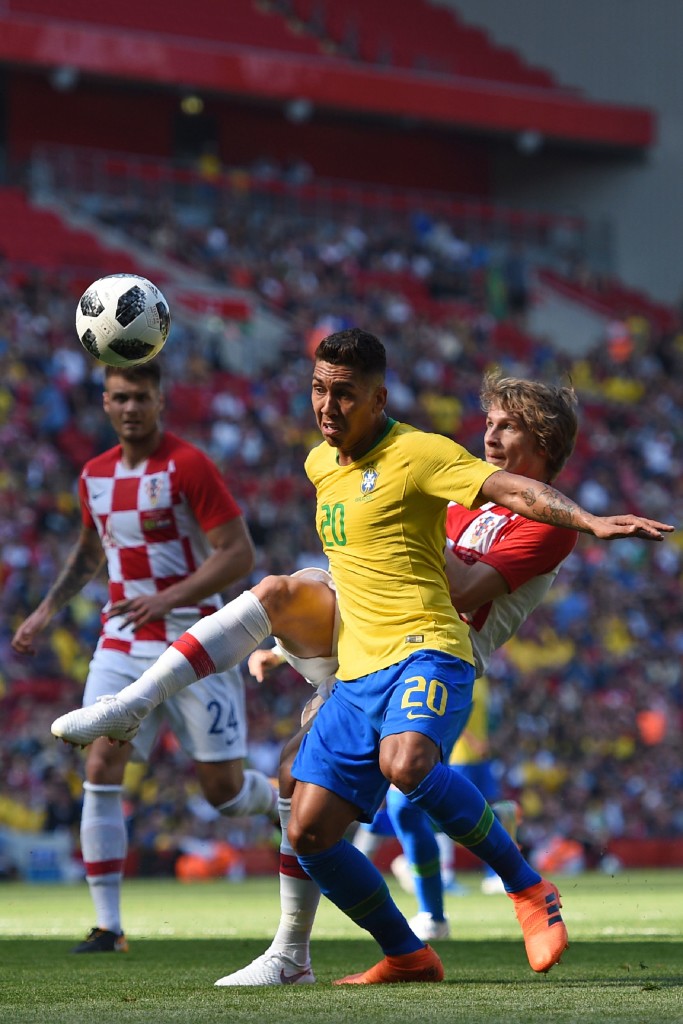 Brazil's striker Roberto Firmino vies with Croatia's defender Tin Jedvaj is the build-up to scoring their second goal during the International friendly football match between Brazil and Croatia at Anfield in Liverpool on June 3, 2018. - Brazil won the game 2-0. (Photo by Oli SCARFF / AFP) (Photo credit should read OLI SCARFF/AFP/Getty Images)
