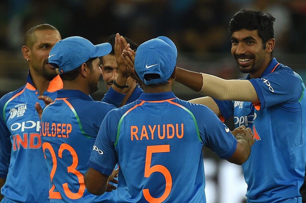 Indian cricketer Jasprit Bumrah (R) celebrates with teammate after dismissing Usman Khan
