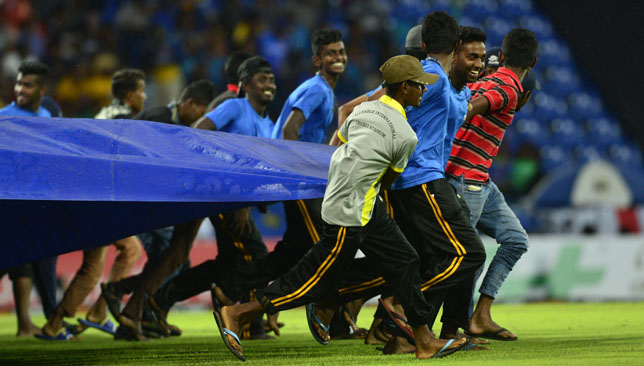 Ground staff cover the pitch in the fourth ODI at Pallekele.